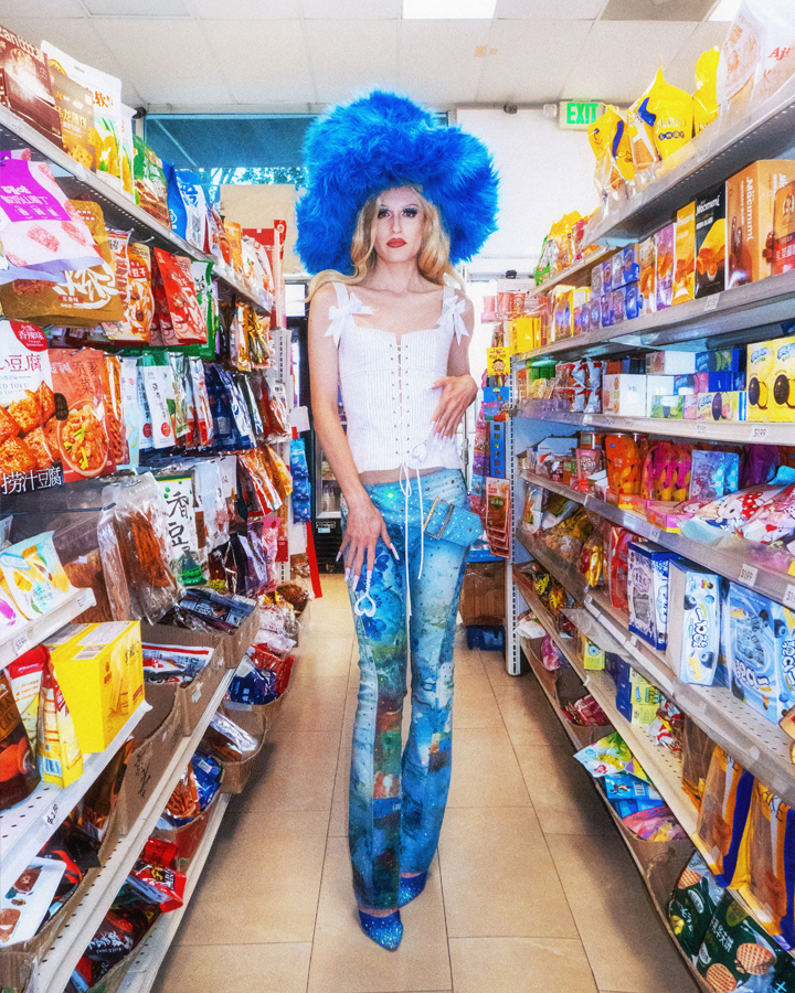 Jesse Clark posing in drag on a private jet with a martini in one hand.
